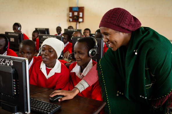 Teacher and students looking at a computer monitor