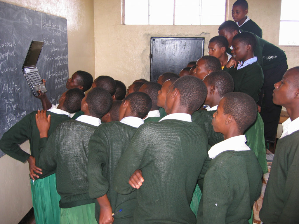 Teacher and students looking at a computer monitor