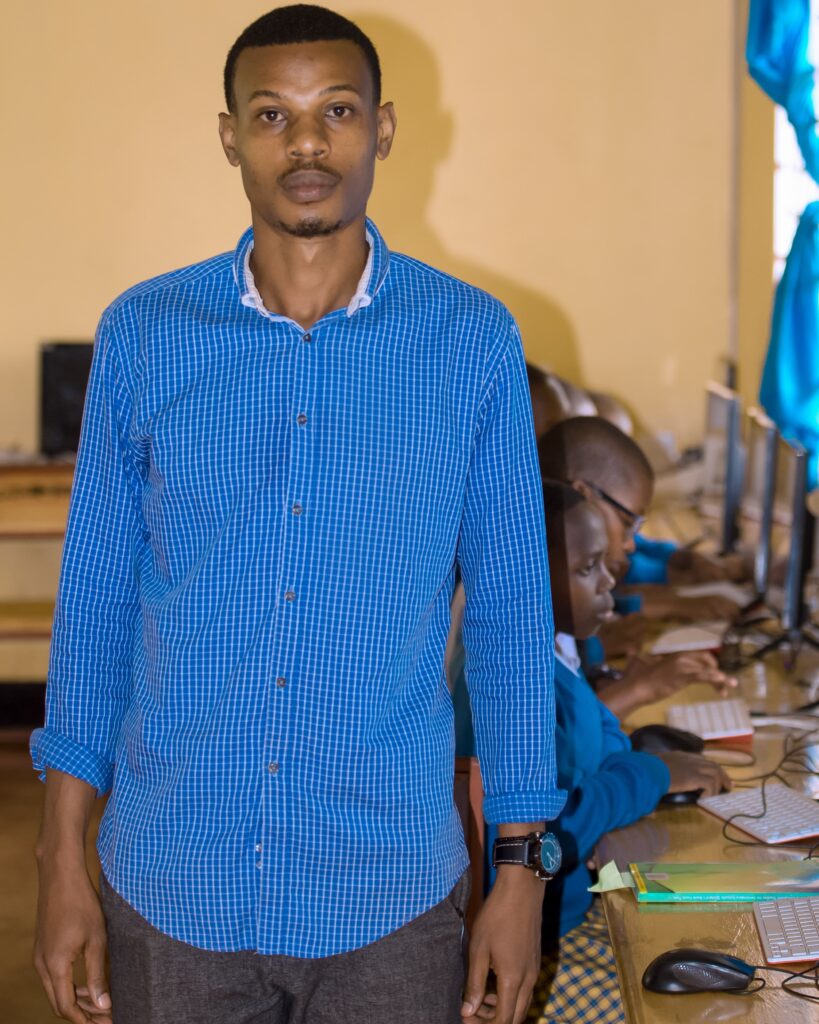 Teacher Tumaini stands in a computer lab in a school in Tanzania