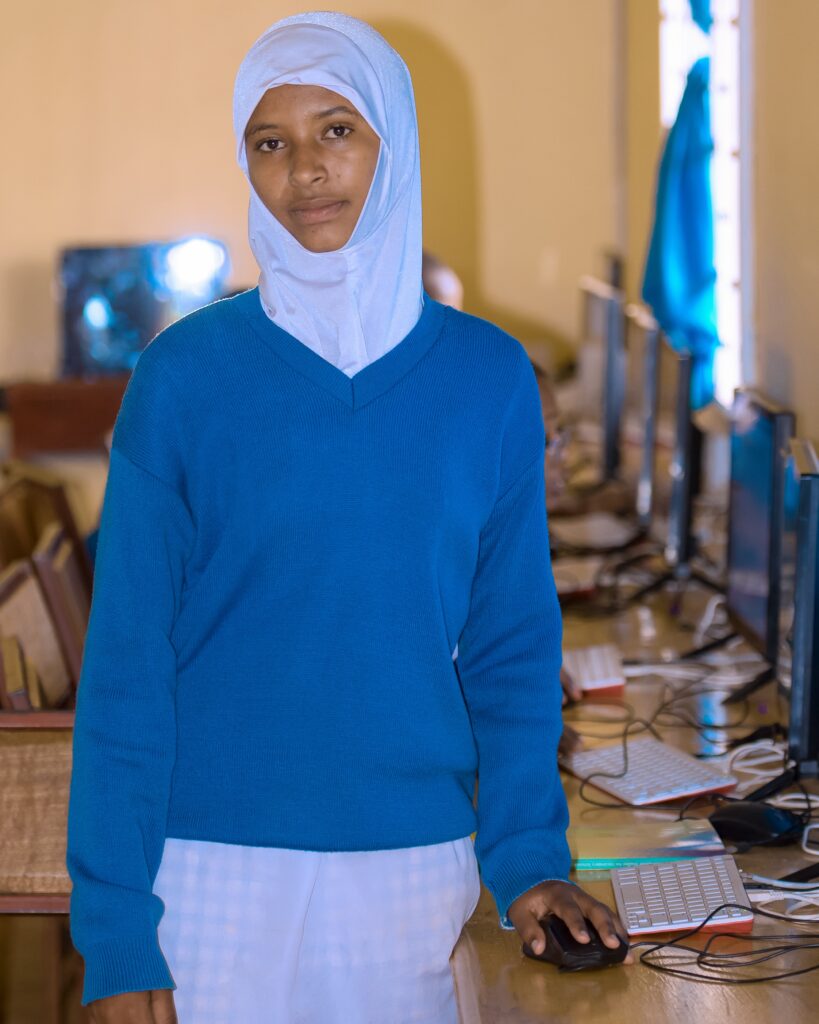 Student Zahara stands in a computer lab in a school in Tanzania.